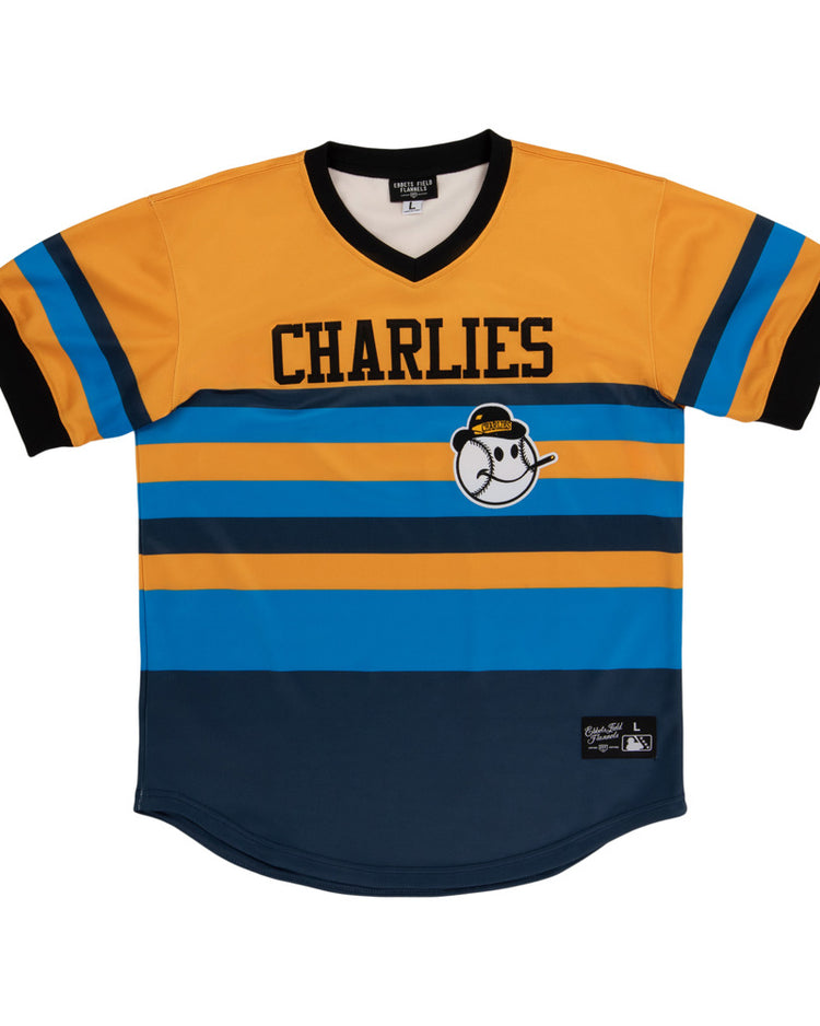 The Ebbets Field Charleston Charlies MiLB Vintage V-Neck Jersey features yellow, blue, and black stripes, CHARLIES text across the chest, and a cartoon baseball character in a yellow cap on the front.
