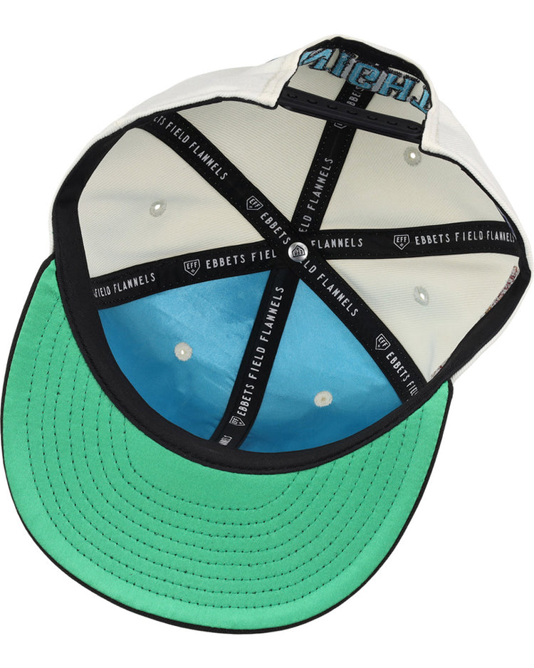 The underside of the Charlotte Knights MiLB Snapback Ballcap by Ebbets Field features a green brim, blue crown lining, black taping with “EBBETS FIELD FLANNELS” in white text, plus white eyelets and stitching inside.
