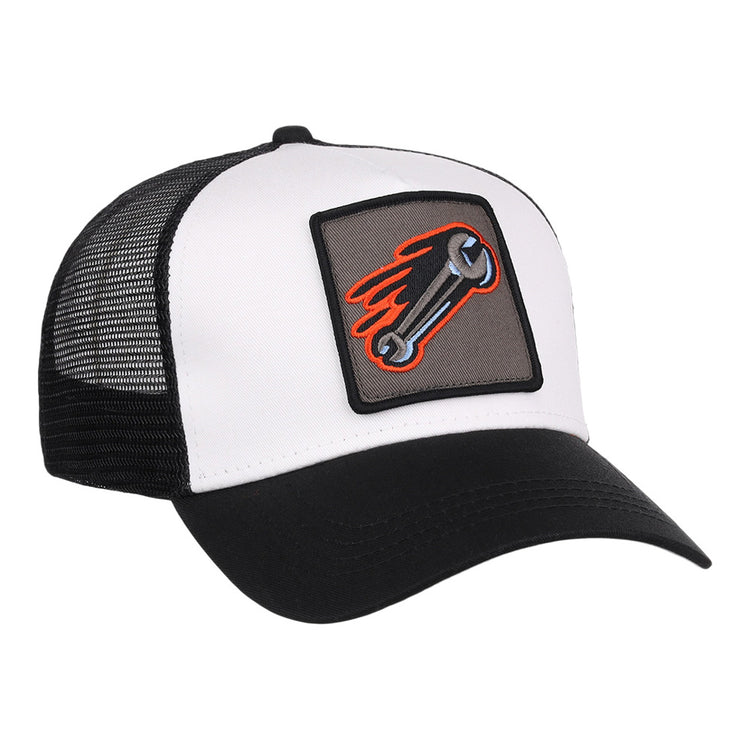 The Inland Empire 66Ers MiLB Trucker Ballcap by Ebbets Field is a black and white hat with a mesh back and a front patch showing a flaming wrench on a gray background.