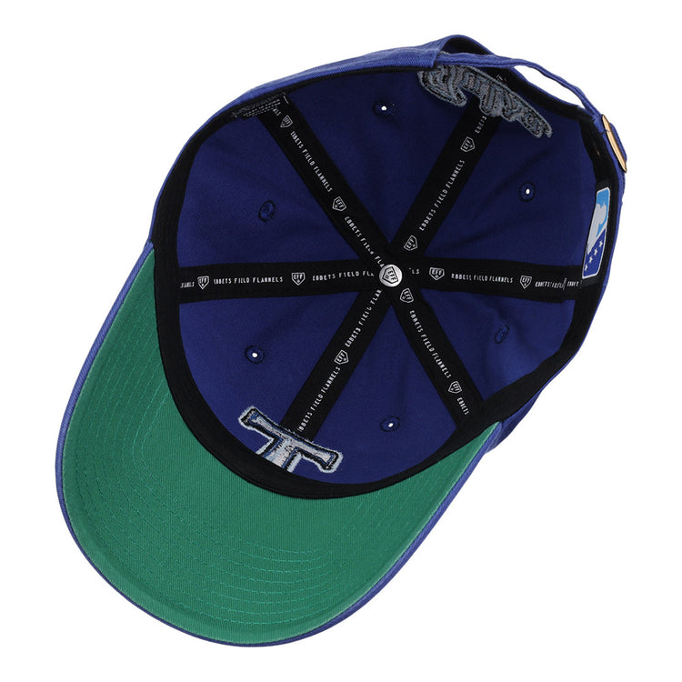 The Ebbets Field Tulsa Drillers MiLB Dad Ballcap features blue and green panels, a black cross-shaped inner lining with text, embroidered details, a band tag, and a green underside on the brim.
