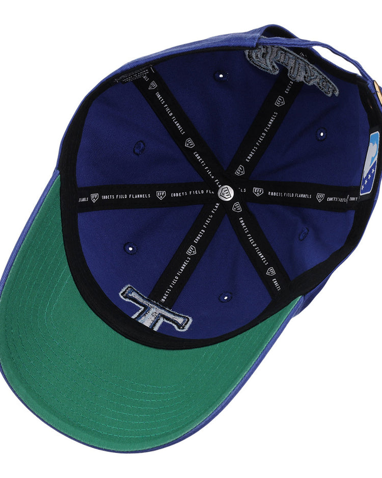 The Ebbets Field Tulsa Drillers MiLB Dad Ballcap features blue and green panels, a black cross-shaped inner lining with text, embroidered details, a band tag, and a green underside on the brim.