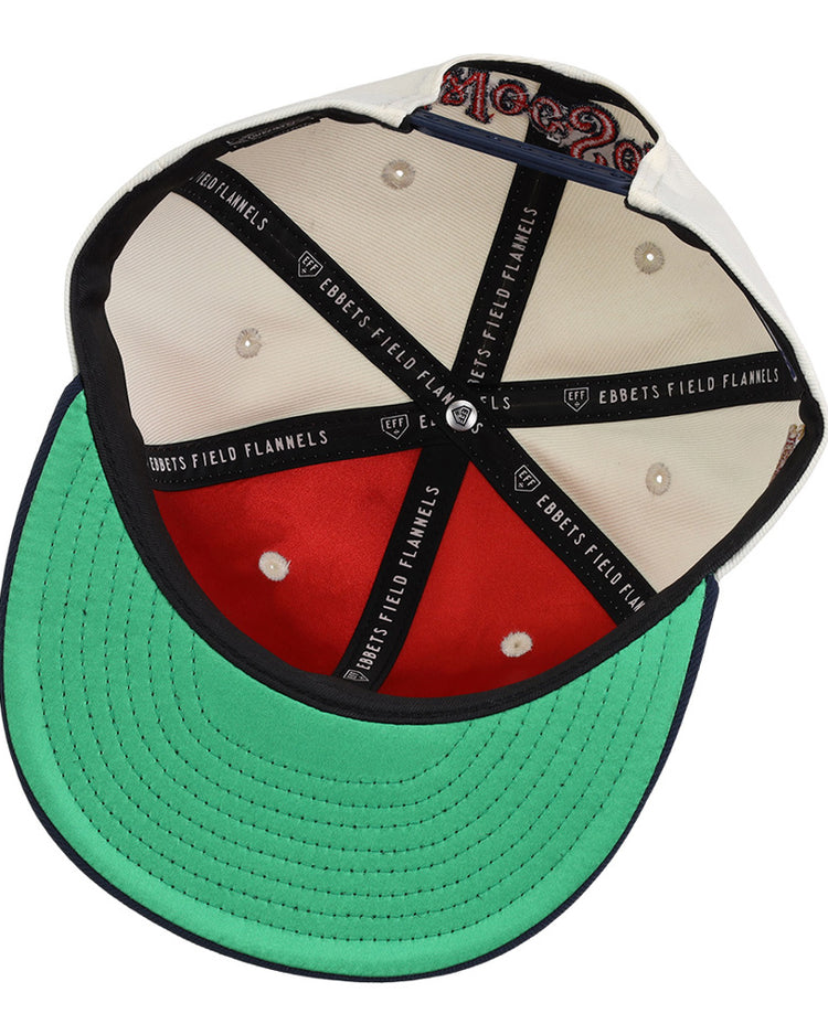 This image shows the inside of the Ebbets Field Worcester Red Sox MiLB Snapback Ballcap, featuring black cross bands with Ebbets Field branding, cream fabric panels, a green underbill, visible stitching, and a size tag.