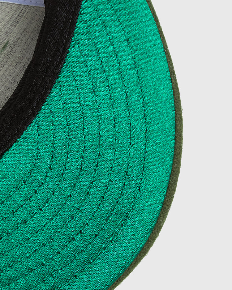 Close-up of the bright green underside of a Mission Bears Vintage Inspired Wool Ballcap brim with black stitching.
