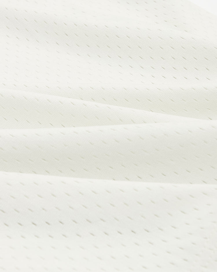 Off-white athletic mesh fabric of a San Francisco Sea Lions V-Neck Mesh Jersey by Ebbets Field with small, evenly spaced perforations, draped in soft folds.