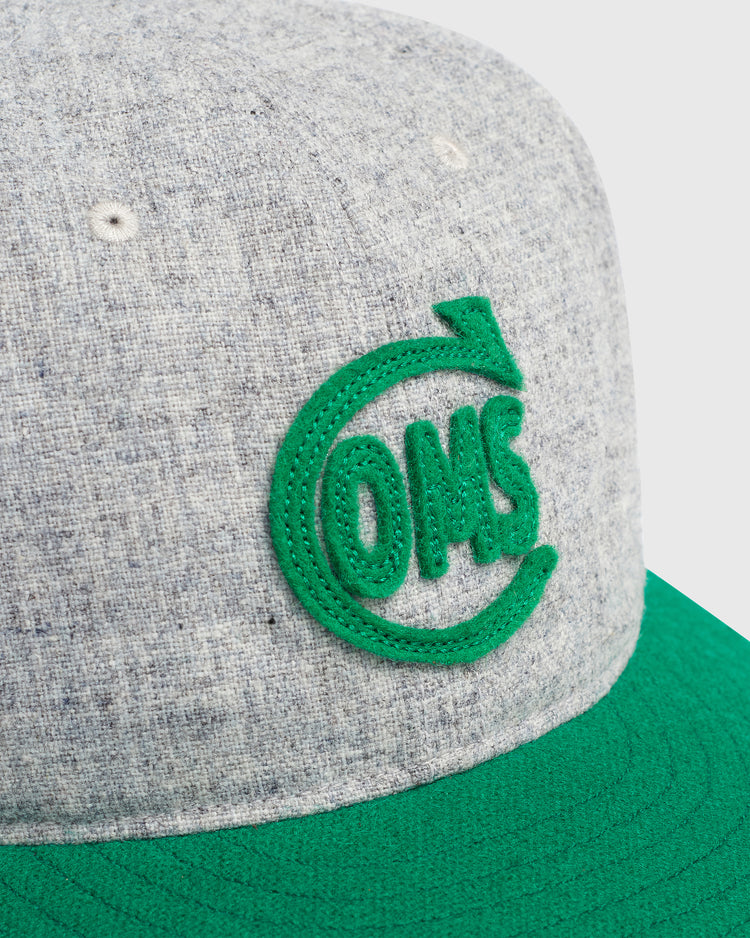 Mystery Caps of Mexico – Comunicaciones 1931 Wool Ballcap in grey wool with a flat green brim and a green felt logo of the letters OMS encircled by an arrow.