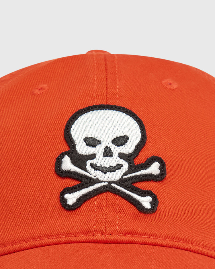 Vintage orange Sioux City Ghosts Washed Cotton Ballcap by Ebbets Field featuring an embroidered white skull and crossbones patch on the front.