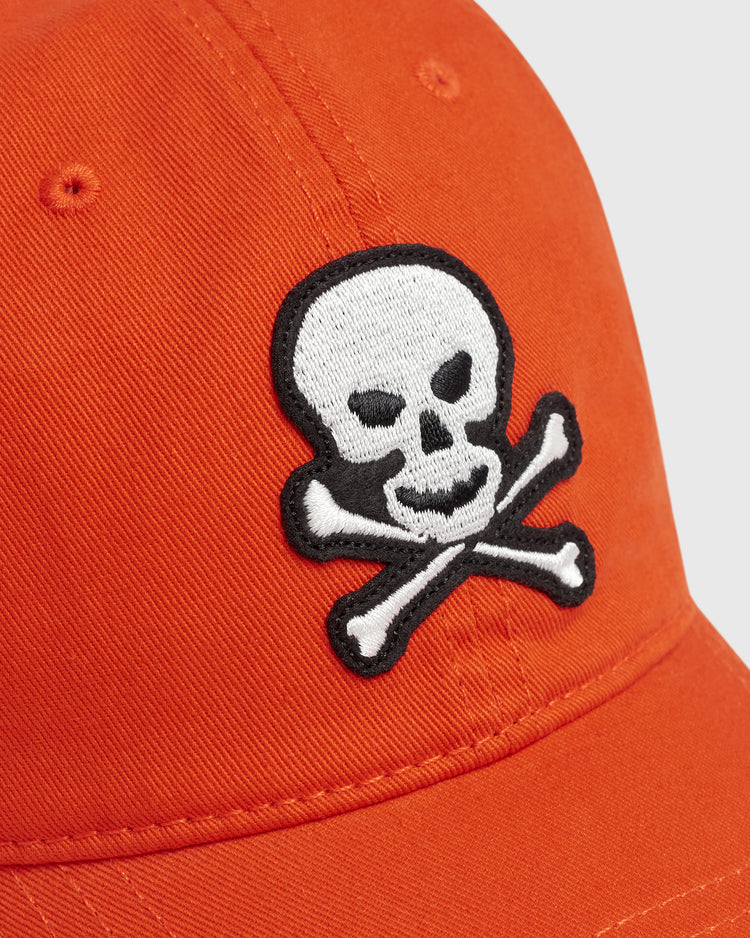 Orange cotton Sioux City Ghosts Washed Cotton Ballcap featuring an embroidered white skull and crossbones emblem with a black outline.
