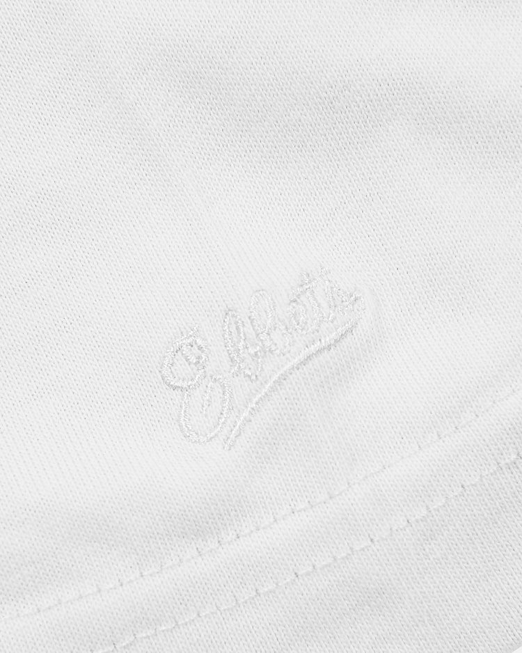 Close-up of the Hawaii Islanders (PCL) Graphic Short Sleeve Tee by Ebbets Field, featuring white fabric with Elliott embroidered in cursive near a stitched seam.