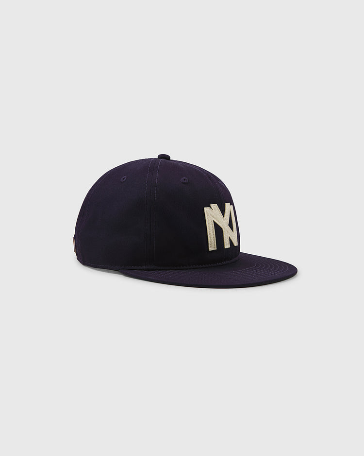 The Brooklyn Eagles Cotton Twill Ballcap by Ebbets Field in navy features a flat brim and bold white NY lettering on the front, shown against a plain light gray background.