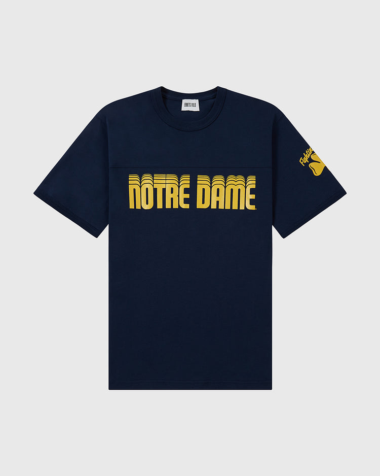 The Ebbets Field NOTRE DAME FOOTBALL TEE NAVY features bold yellow “NOTRE DAME” lettering on the chest and a yellow shamrock with text on the left sleeve.
