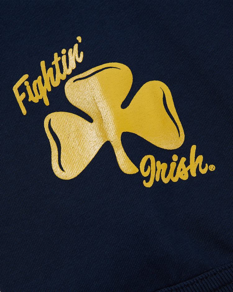 The NOTRE DAME FOOTBALL TEE NAVY by Ebbets Field features navy blue fabric with a gold shamrock and Fightin Irish in yellow, stylized text.