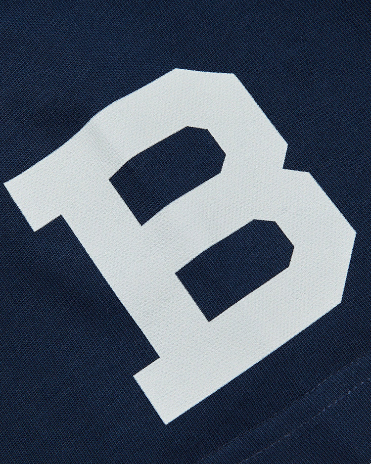 A large white letter B is printed on dark blue fabric on the Brooklyn Bushwicks Ebbets Tee with Back Print by Ebbets Field.