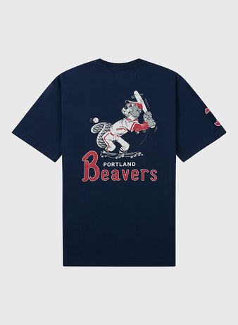 The Ebbets Field Portland Beavers Ebbets Tee with Back Print is a navy blue shirt featuring a vintage-style beaver in a baseball uniform with a bat and “PORTLAND Beavers” text below the image.