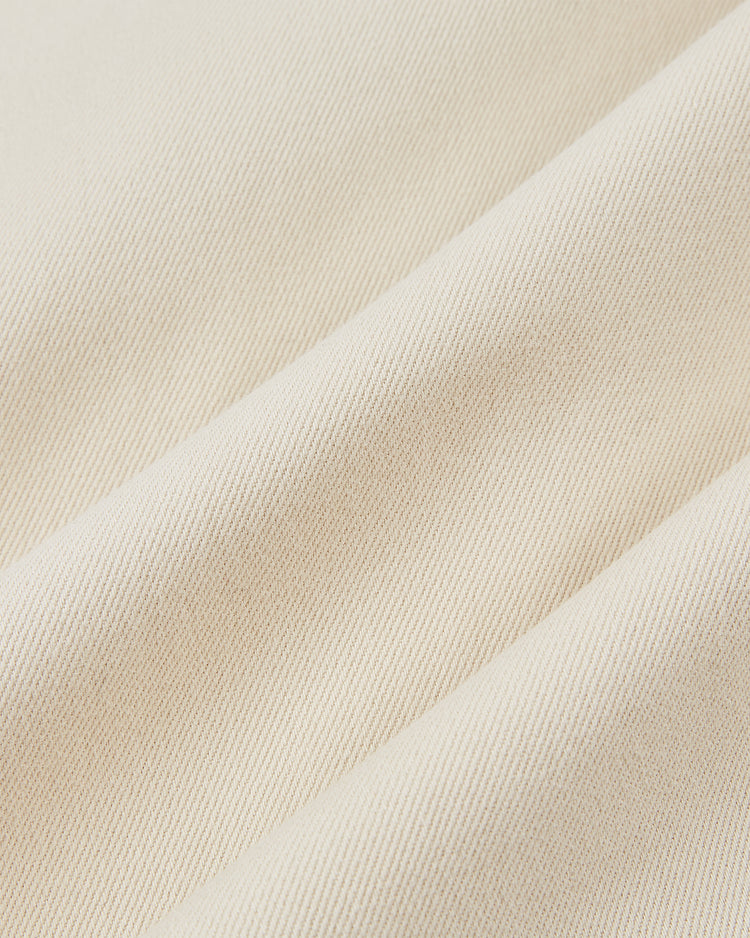 Close-up of Ebbets Field HARVARD COTTON TWILL JERSEY Natural fabric, showcasing its light beige color, diagonal ribbed texture, and detailed weave pattern with soft shadows.