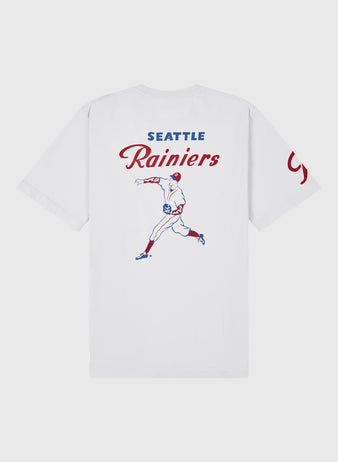 Ebbets Field Seattle Rainiers Ebbets Tee with Back Print: White tee with blue and red baseball player graphic, SEATTLE Rainiers above, and partially visible red text on the right sleeve.