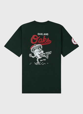 The Ebbets Field Oakland Oaks Ebbets Tee features a black design with Oakland Oaks in red and white on the back, a cartoon tossing peanuts above Est. 1903, plus a graphic on the left sleeve.