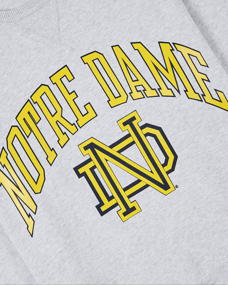 Ebbets Field NOTRE DAME CREWNECK SS H-GRY: gray sweatshirt with bold yellow and black NOTRE DAME arch and large matching intertwined ND logo.