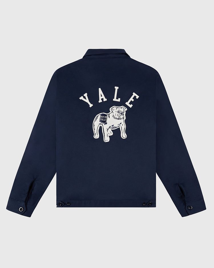 The Ebbets Field YALE GROUNDS CREW JACKET in navy features YALE in white arched letters above a white bulldog graphic on the back, with buttoned cuffs and a classic collar. Displayed on a plain light background.