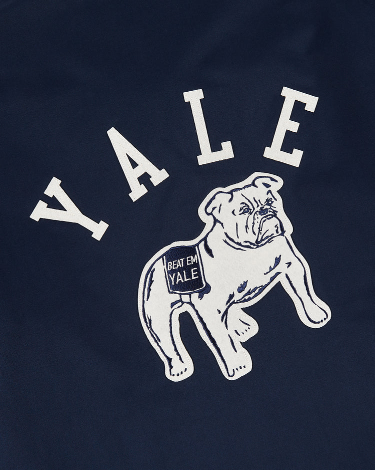 The Ebbets Field YALE GROUNDS CREW JACKET in navy displays YALE in bold white letters above an illustrated bulldog sporting a Beat Em Yale blanket.