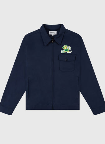 The Ebbets Field NOTRE DAME GROUNDS CREW JACKET in navy features a zip-up front, chest pocket, and a colorful lizard patch above the pocket, shown on a light gray background.