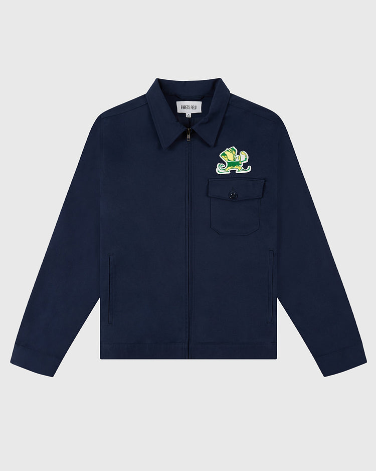 The Ebbets Field NOTRE DAME GROUNDS CREW JACKET in navy features a zip-up front, chest pocket, and a colorful lizard patch above the pocket, shown on a light gray background.