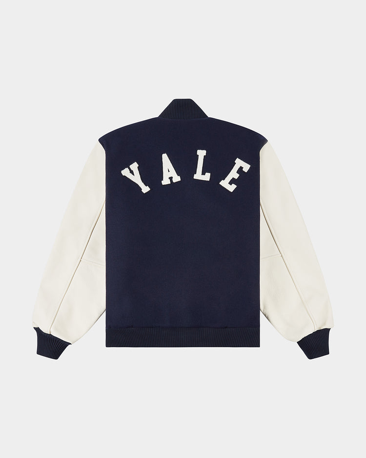 The YALE VARSITY JACKET Navy by Ebbets Field features a navy body, cream sleeves, and bold white YALE lettering across the back for a classic varsity look.