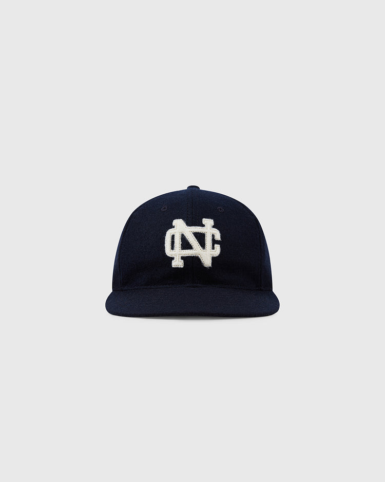The Ebbets Field Flannels University of North Carolina 1960 Vintage Ballcap is a navy wool cap featuring a white embroidered NC logo, inspired by the original 1960 design and shown against a plain light gray background.