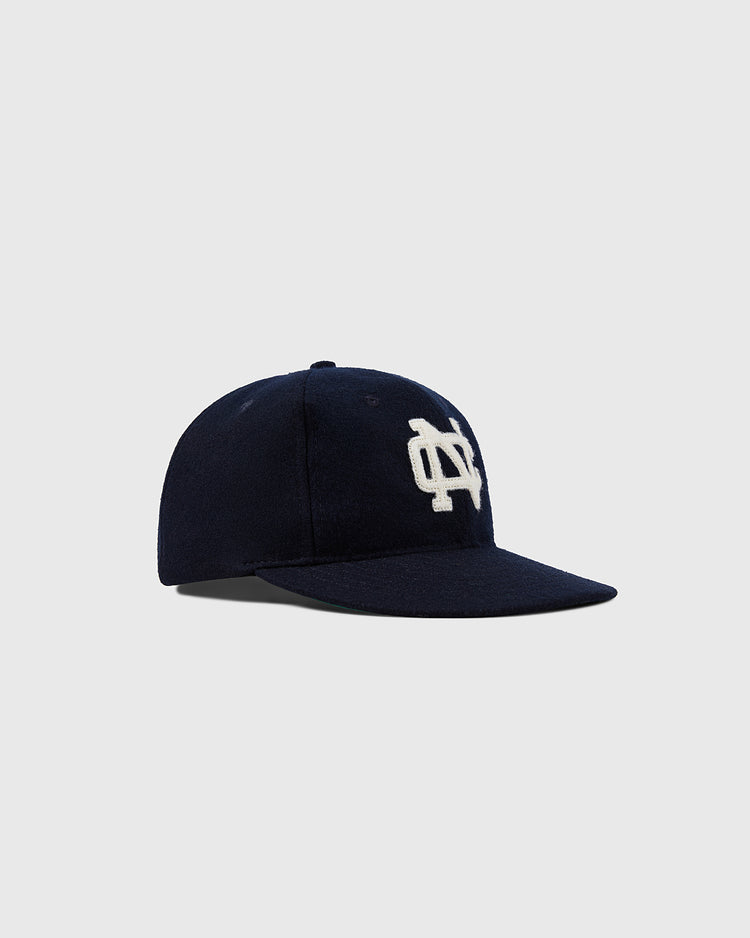 The Ebbets Field Flannels University of North Carolina 1960 Vintage Ballcap is a navy wool cap featuring a white interlocking ND logo on the front, displayed against a plain light gray background.