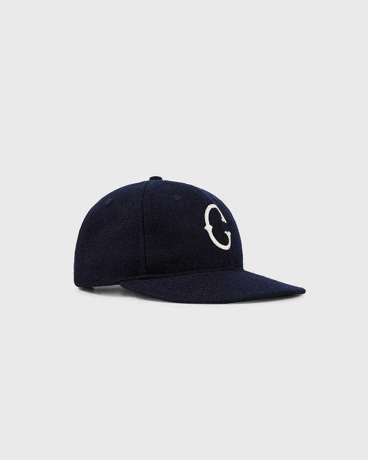 The EFF University of Connecticut 1957 Vintage Ballcap features a navy blue design with a curved brim and white embroidered “C” on the front, shown on a light gray background—a stylish tribute to the UCONN Huskies.