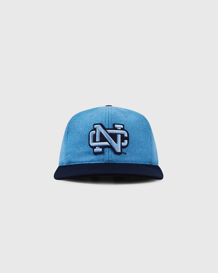 The EFF University of North Carolina 1983 Vintage Ballcap showcases a bold, white-outlined N logo on the front, blue crown with navy brim, and is displayed on a plain light gray background.