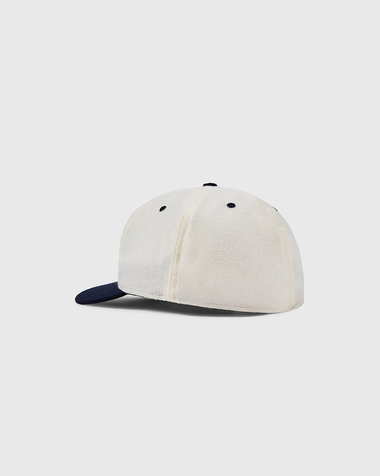 The EFF University of Connecticut Huskies Vintage Ballcap is cream-colored with a dark blue visor and button, shown from the back at an angle on a plain light gray background.