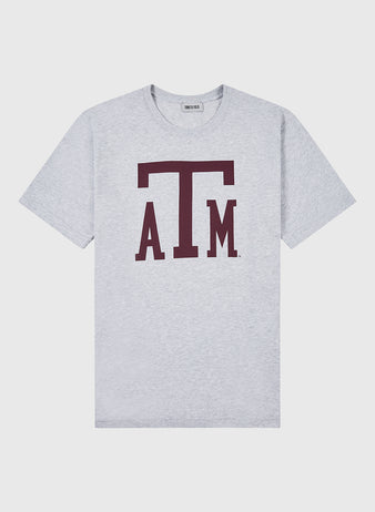 The Ebbets Field TEXAS A&M SS TEE H-GRY is a light gray T-shirt with a prominent maroon ATM Texas A&M University logo on the front.