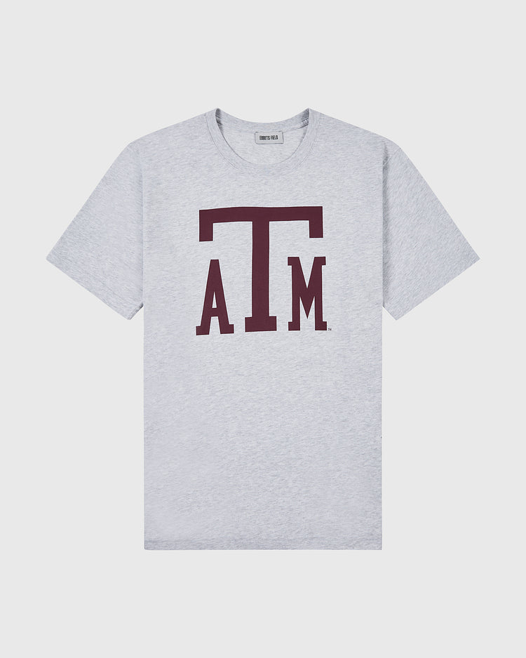 The Ebbets Field TEXAS A&M SS TEE H-GRY is a light gray T-shirt with a prominent maroon ATM Texas A&M University logo on the front.