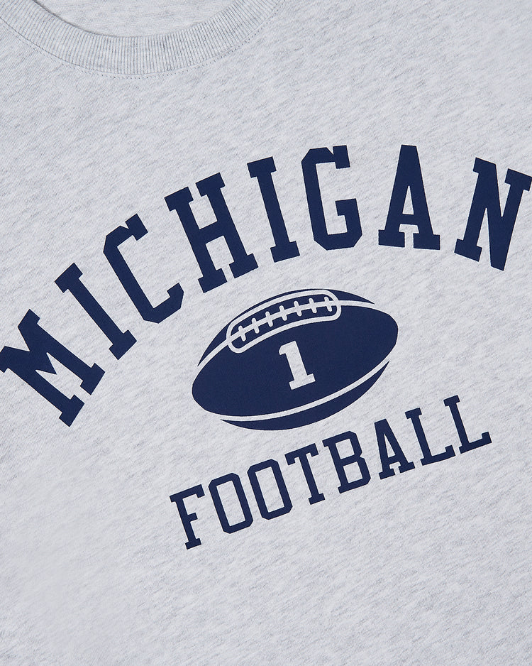 Ebbets Field MICHIGAN SS TEE H-GRY features the word MICHIGAN in bold navy letters over a football marked with the number 1, with FOOTBALL in matching navy below.