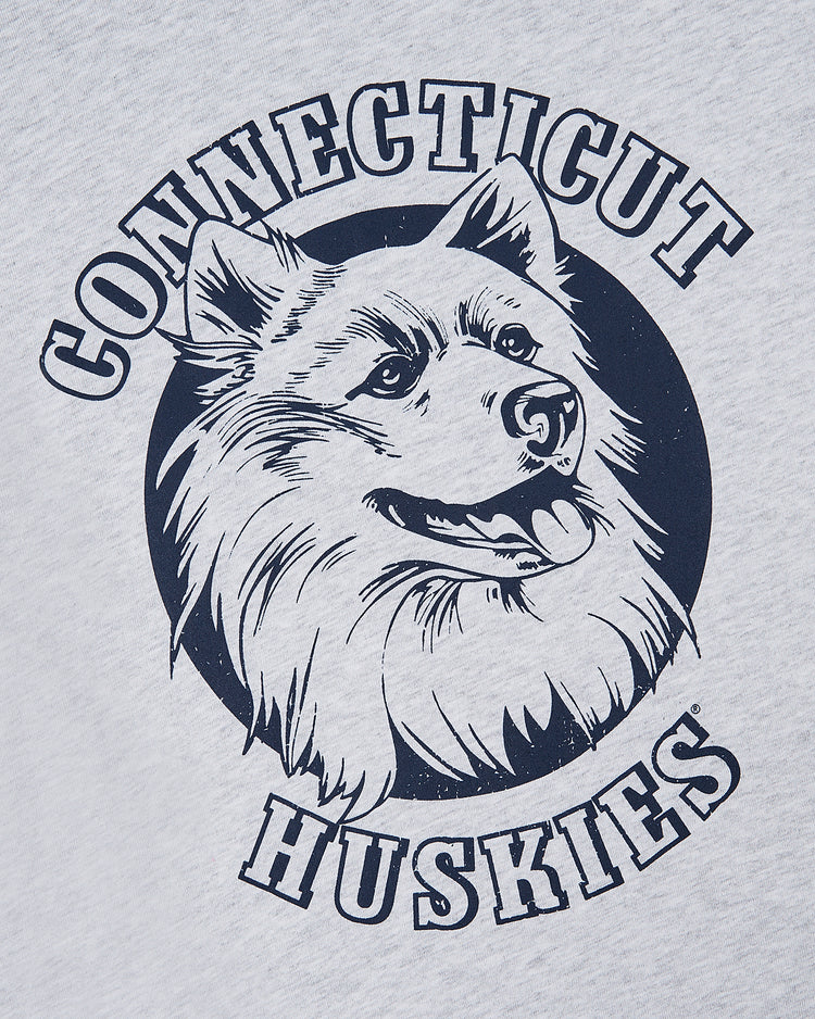 The Ebbets Field UCONN SS TEE H-GRY features a navy illustration of a huskys head in a circle with bold “Connecticut Huskies” text above and below, printed on a light gray tee.
