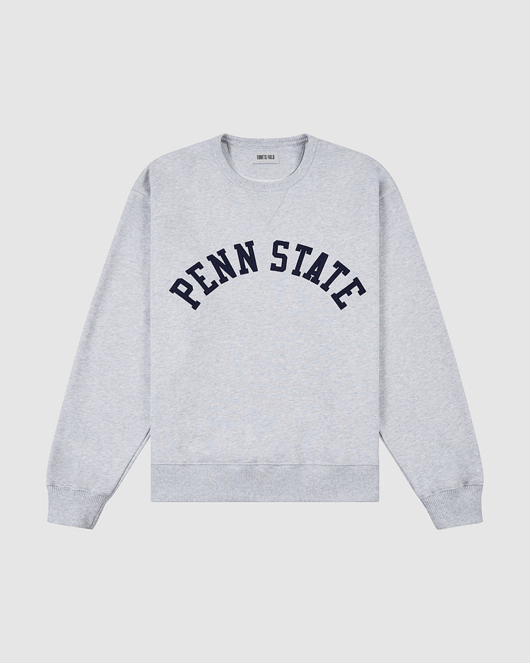 The PENN STATE CREWNECK SS H-GRY by Ebbets Field is a light gray sweatshirt featuring “PENN STATE” in bold navy block letters on the chest, with ribbed cuffs, collar, and hem.
