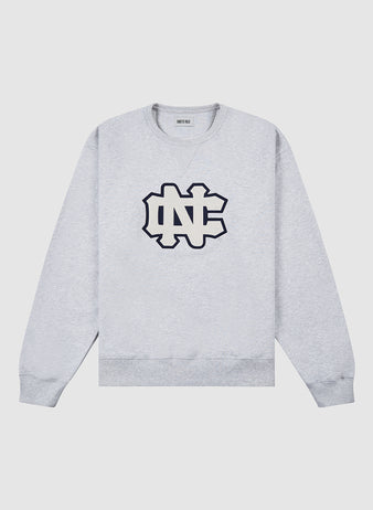 The Ebbets Field UNIVERSITY OF NORTH CAROLINA CREWNECK SS H-GRY is a light gray sweatshirt with a large black-outlined NC chest logo and ribbed cuffs, collar, and hem, shown on a plain white background.
