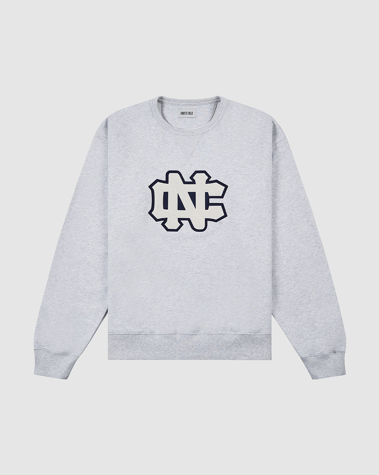 The Ebbets Field UNIVERSITY OF NORTH CAROLINA CREWNECK SS H-GRY is a light gray sweatshirt with a large black-outlined NC chest logo and ribbed cuffs, collar, and hem, shown on a plain white background.