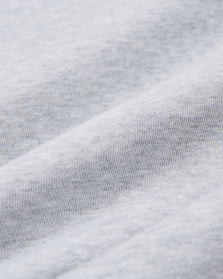 Close-up of the Ebbets Field UNIVERSITY OF NORTH CAROLINA CREWNECK SS H-GRY shows its light gray fabric, featuring a soft, smooth texture with gentle folds and fine knit details.