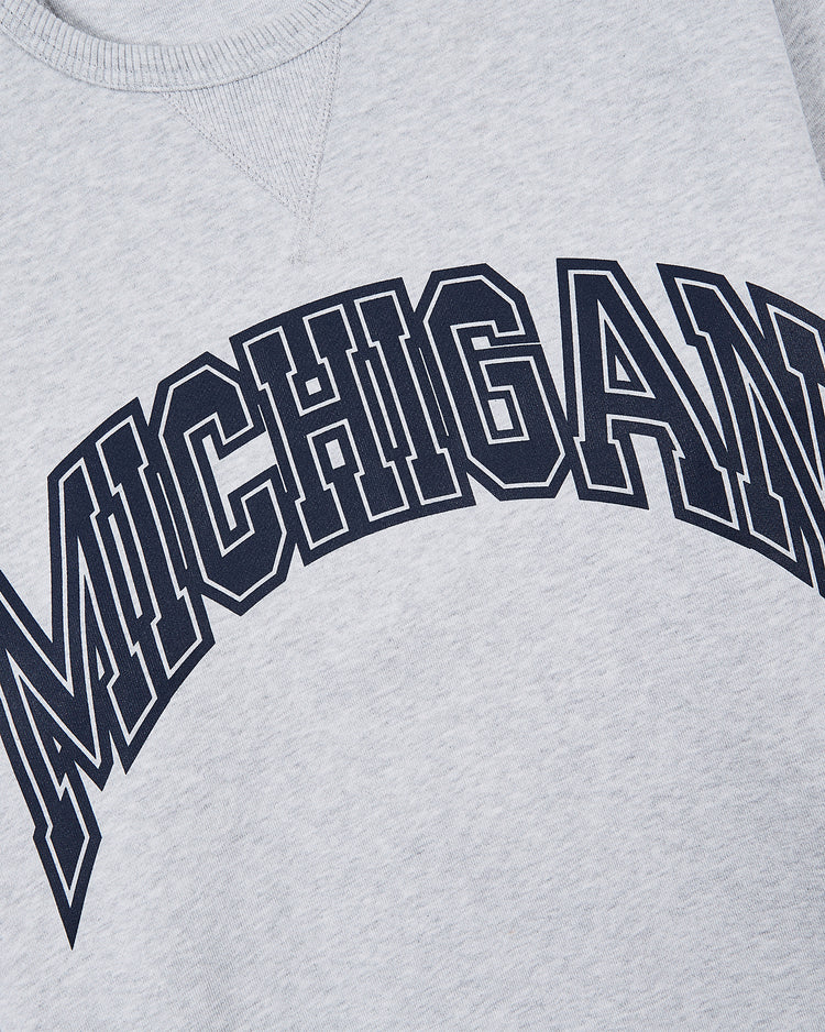 The Ebbets Field MICHIGAN CREWNECK SS H-GRY is a light gray sweatshirt featuring MICHIGAN in large, bold, black collegiate-style letters across the chest.