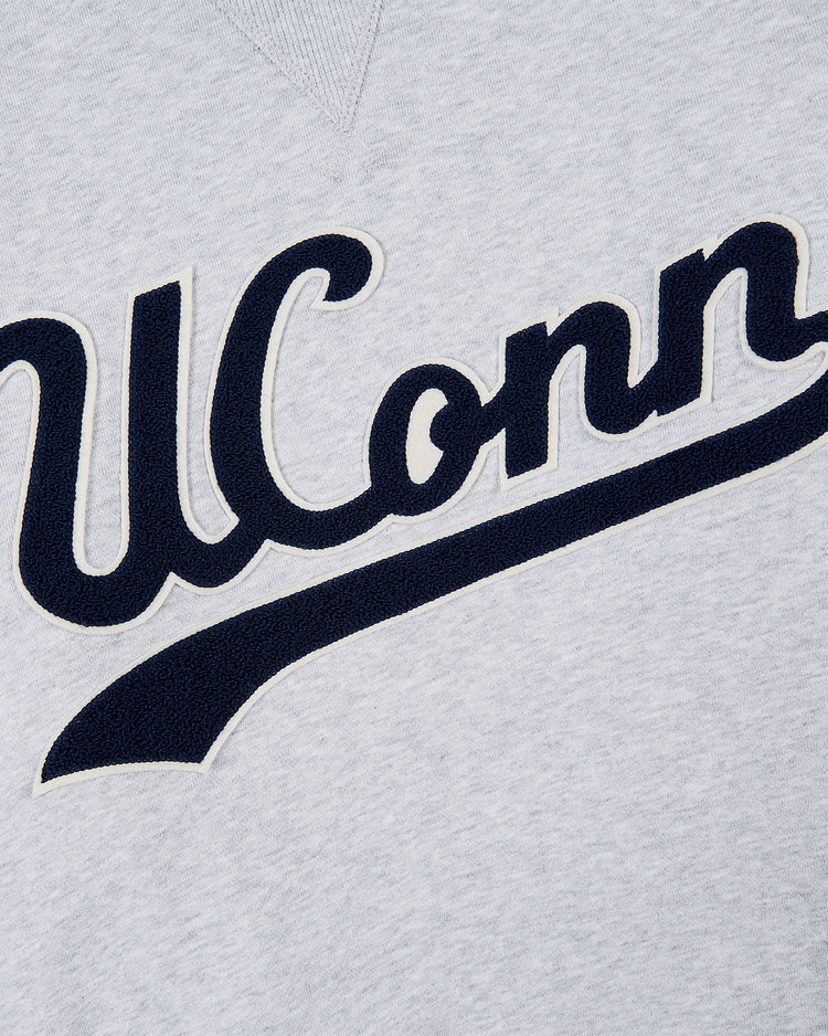 Close-up of the Ebbets Field UCONN CREWNECK SS H-GRY, a light gray sweatshirt featuring UConn in large navy blue and white script letters, evoking classic college style.