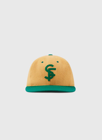 The EFF University of San Francisco Collegiate Wool Ballcap in gold, featuring a green brim and an embroidered C and S logo, is shown against a plain white background.