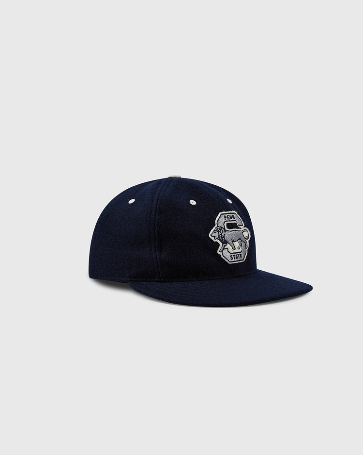 The EFF Penn State University Nittany Lions Vintage Ballcap is a navy blue cap featuring the lion mascot logo on the front, inspired by a 1963 reproduction, set against a light gray background.