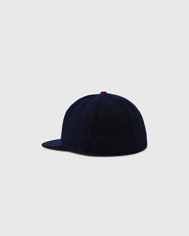 The EFF University of Arizona 1963 Vintage Ballcap is a dark navy wool cap, seen from the back left with a curved brim, red top button, and shown against a light gray background.