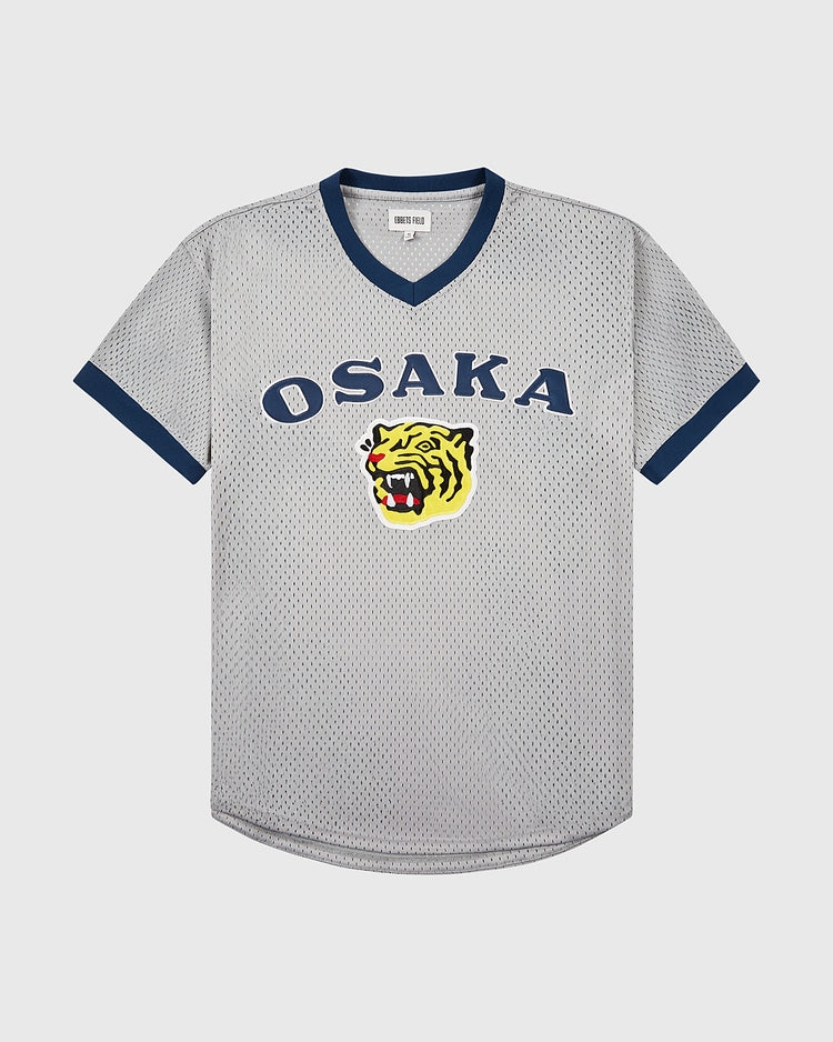 The Ebbets Field Osaka Tigers Mesh V-Neck Jersey features gray mesh, navy trim, OSAKA lettering, and a yellow tiger head—paying homage to Japanese baseball and iconic games at Koshien Field.