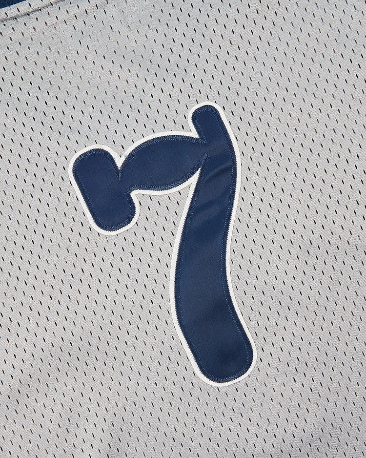 Close-up of a blue number 7 with white outline on a light gray Ebbets Field Osaka Tigers Mesh V-Neck Jersey, inspired by Japanese baseball games at Koshien Field.