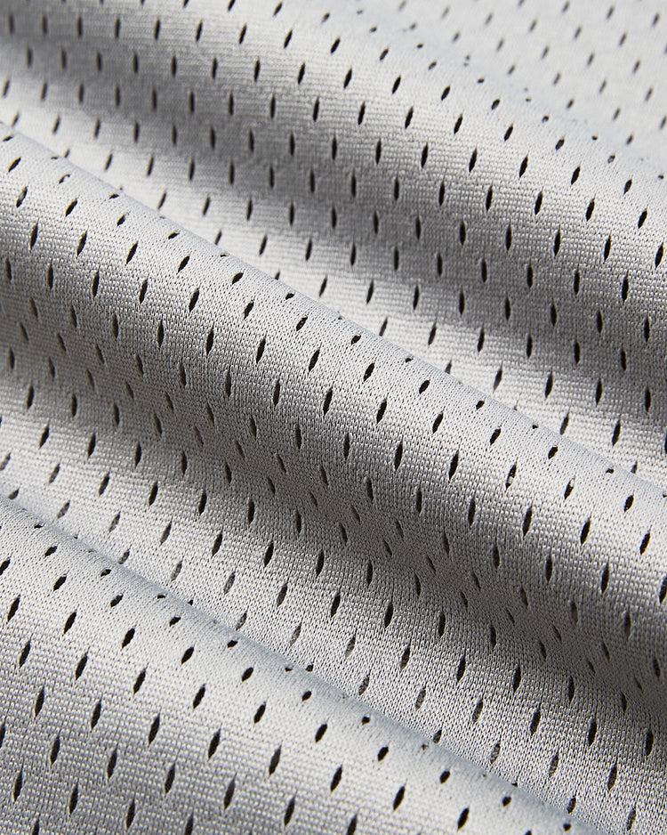 Close-up of light gray mesh fabric with small, even holes and gentle folds, like the breathable material in the Ebbets Field Osaka Tigers Mesh V-Neck Jersey, inspired by those worn at Japanese baseball games.