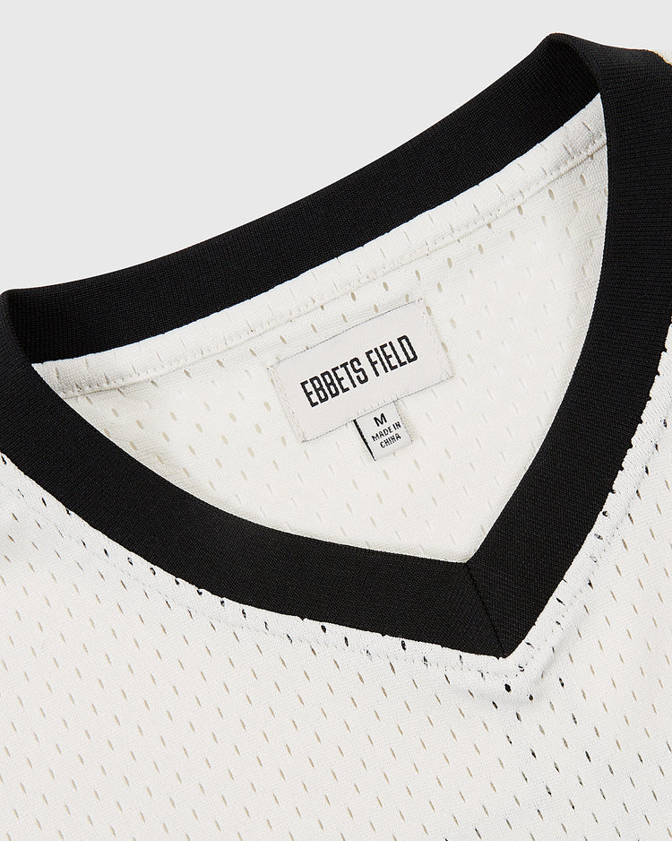Close-up of the Tokyo Giants Mesh V-Neck Jersey by Ebbets Field, featuring a white mesh design, black V-neck collar, and a medium size tag. Inspired by classic Japanese Baseball League jerseys.
