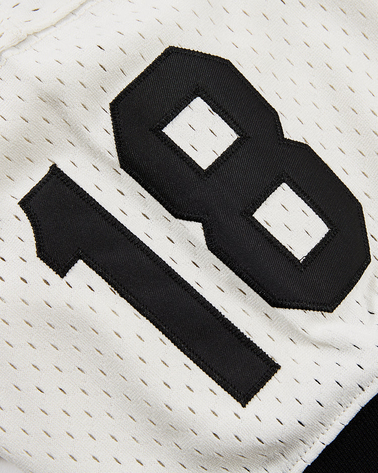 Close-up of an Ebbets Field Tokyo Giants Mesh V-Neck Jersey, inspired by the Japanese Baseball League, with small perforated holes and the number 18 in bold black font.