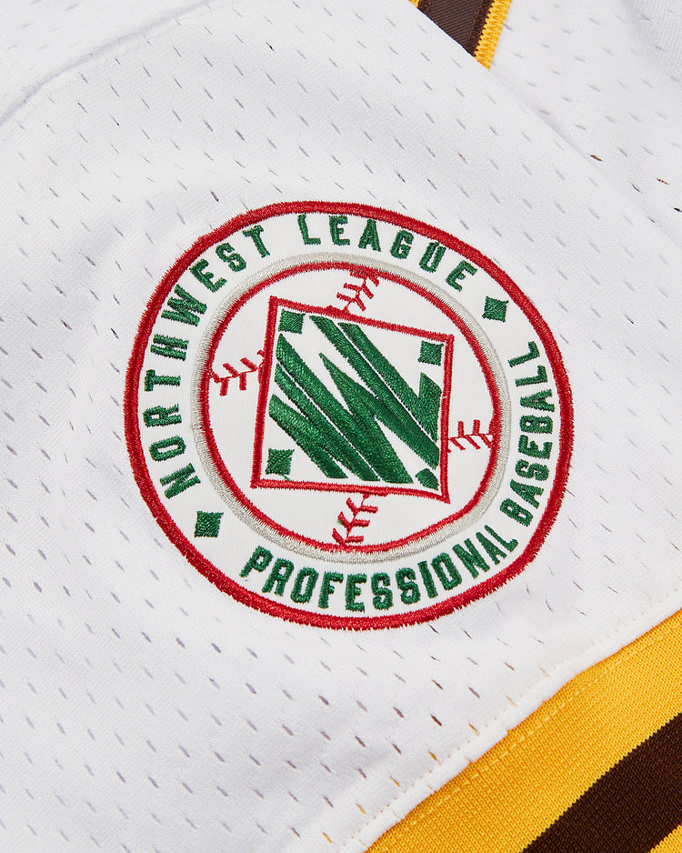 A close-up of the Ozzie Smith Walla Walla Padres Mesh V-Neck Jersey by Ebbets Field, featuring a circular Northwest League patch in green and red, with baseball stitching and a nod to the San Diego Padres at its center.